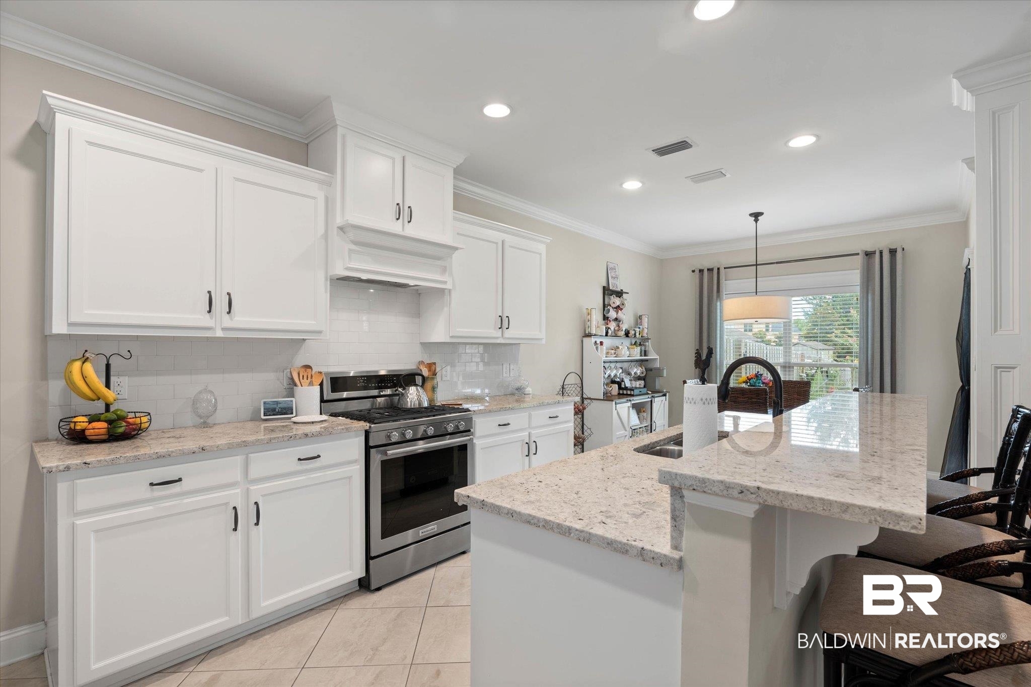 24821 Austin Road Daphne, AL 36526 - Photo 8 of 24 Kitchen with gas range, a kitchen bar, tasteful backsplash, white cabinetry, and custom exhaust hood