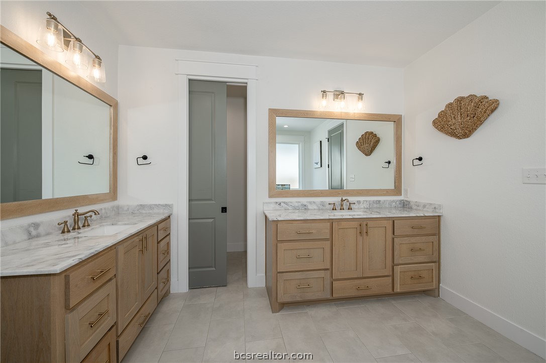 3317 Stone Leigh Lane Bryan, TX 77808 - Photo 13 of 30 a bathroom with a granite countertop sink a large mirror and a vanity