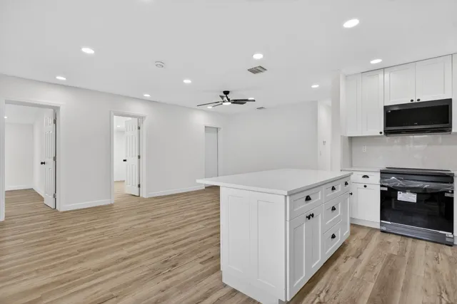 a kitchen with stainless steel appliances a refrigerator sink and microwave