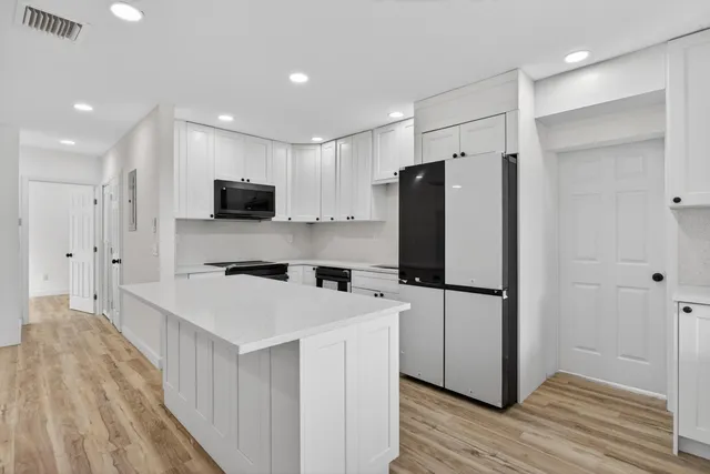 a kitchen with stainless steel appliances a sink a stove a refrigerator and cabinets