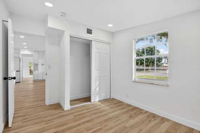 a view of a hallway with wooden floor and entryway