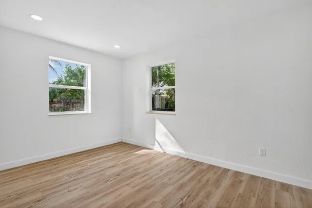 a view of empty room with wooden floor and cabinet