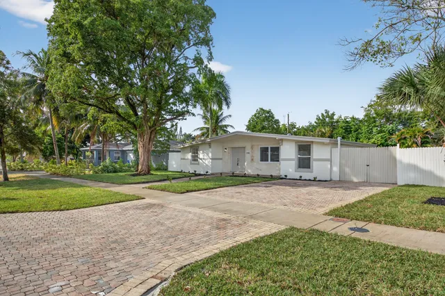 a front view of a house with a yard and trees