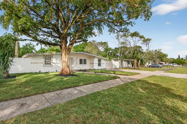 a view of a house with backyard and a tree
