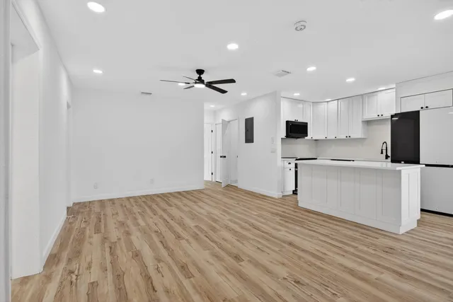 a view of kitchen with stainless steel appliances refrigerator stove microwave and cabinets