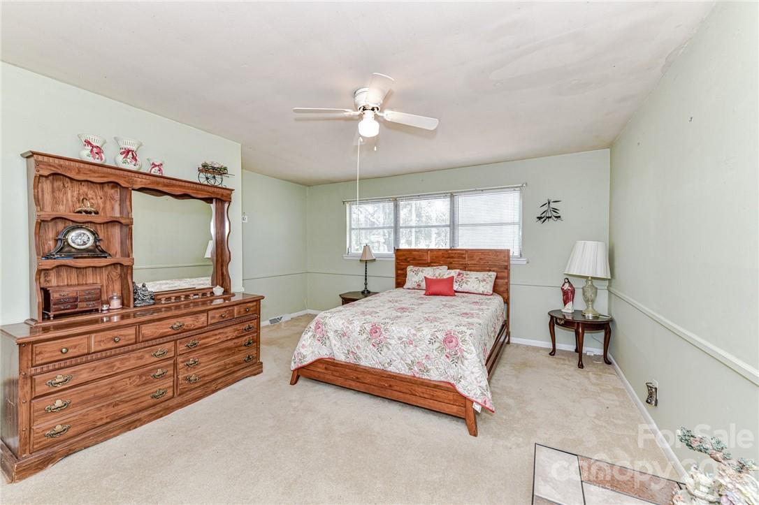 6308 Indian Trail Fairview Road Hemby Bridge, NC 28079 - Photo 25 of 36 a bedroom with a bed and dresser with mirror