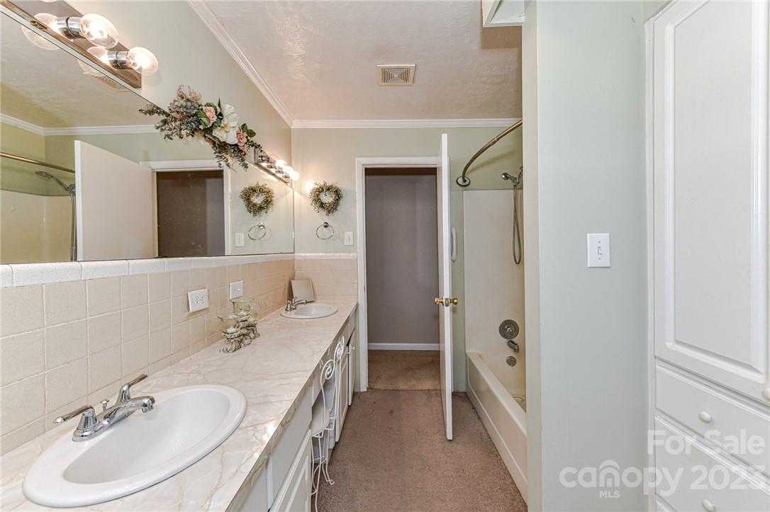 6308 Indian Trail Fairview Road Hemby Bridge, NC 28079 - Photo 27 of 36 a en suite bathroom with a double vanity sink a mirror and a bathtub