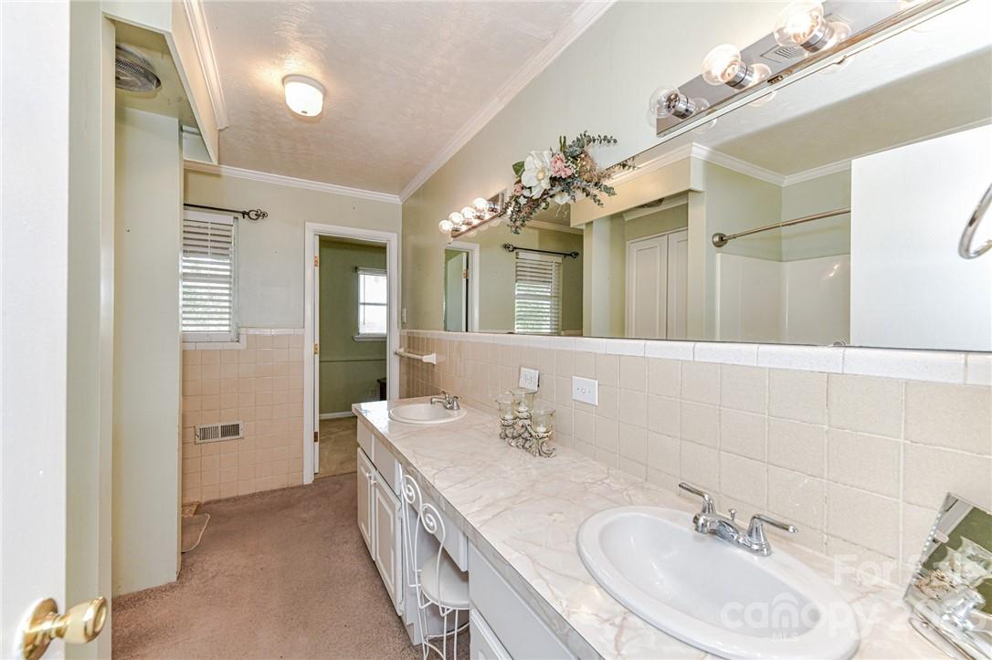 6308 Indian Trail Fairview Road Hemby Bridge, NC 28079 - Photo 28 of 36 a bathroom with a double vanity sink and a mirror