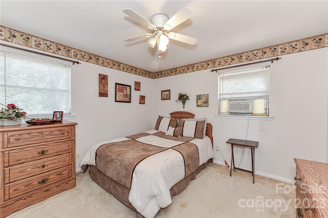 6308 Indian Trail Fairview Road Hemby Bridge, NC 28079 - Photo 32 of 36 a bedroom with a bed and a chandelier
