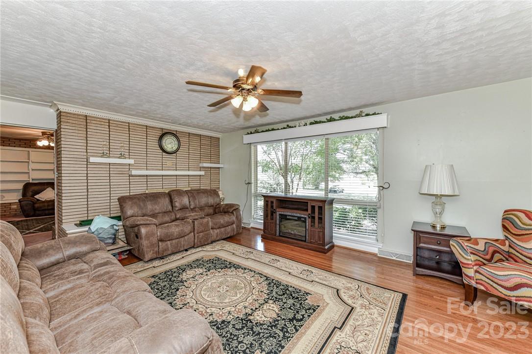 6308 Indian Trail Fairview Road Hemby Bridge, NC 28079 - Photo 9 of 36 a living room with furniture a flat screen tv and a fireplace