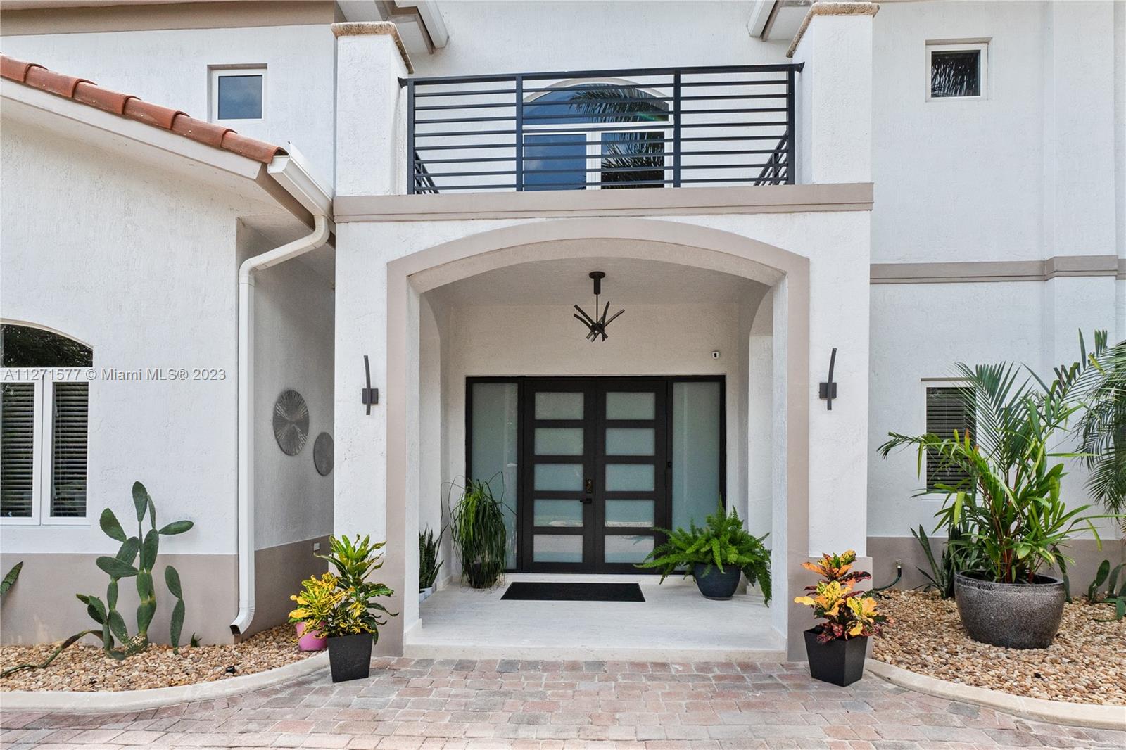 7740 Southwest 128th Street Pinecrest, FL 33156 - Photo 43 of 56 a front view of a house with potted plants