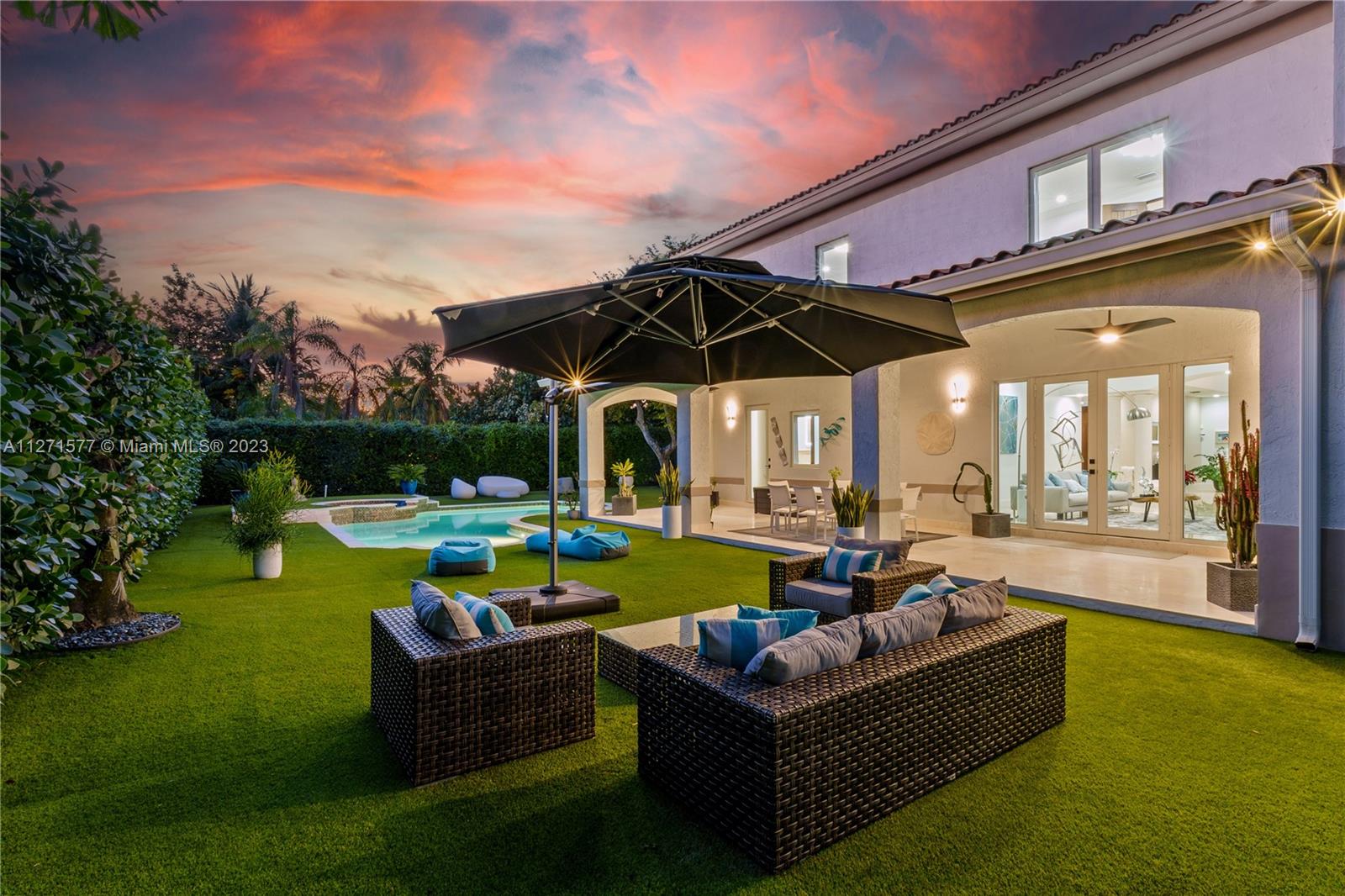 7740 Southwest 128th Street Pinecrest, FL 33156 - Photo 47 of 56 a view of a house with swimming pool and couches in a patio