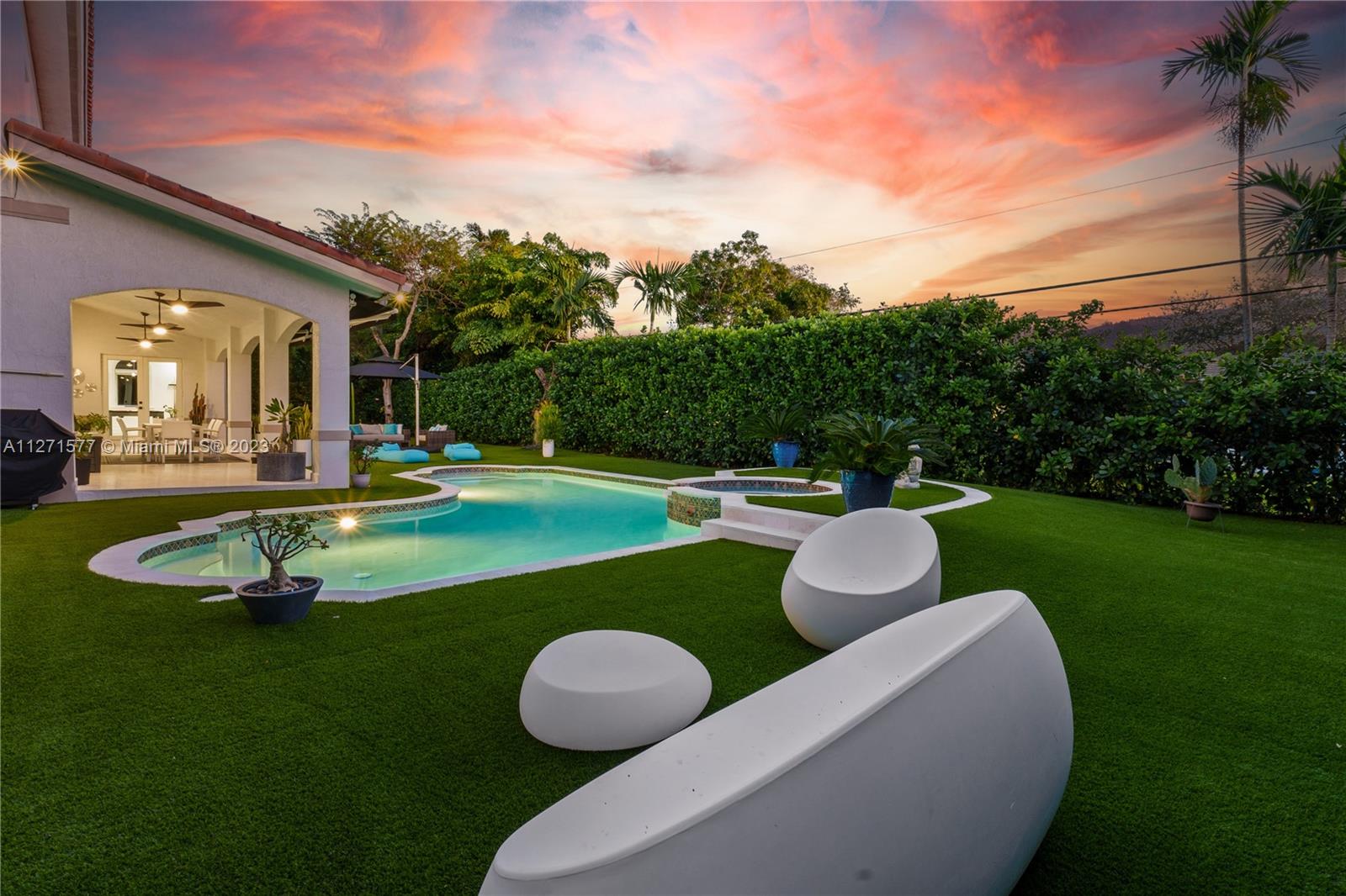 7740 Southwest 128th Street Pinecrest, FL 33156 - Photo 49 of 56 a view of a white house with a yard table and chairs