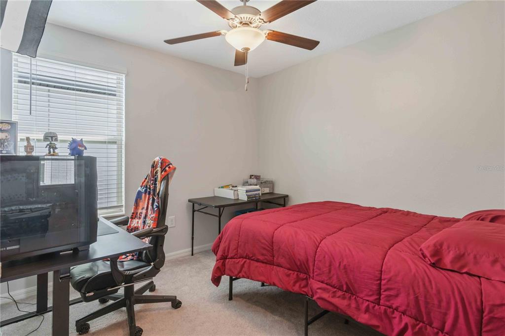 9440 Lemon Drop Loop Sun City Center, FL 33573 - Photo 42 of 55 a bedroom with a bed and a chandelier