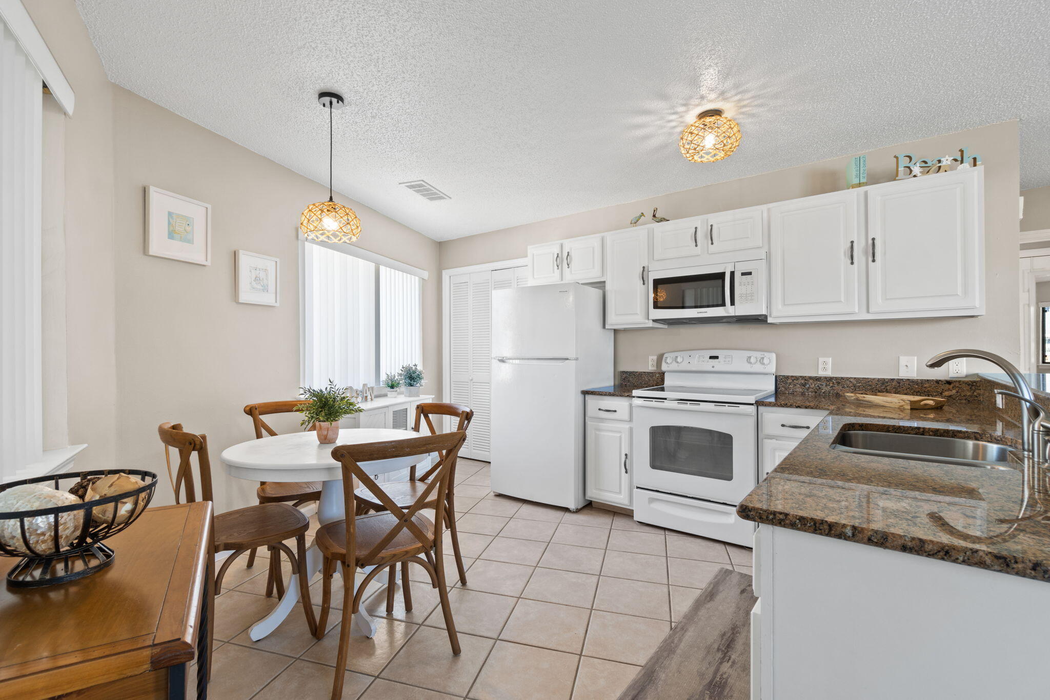 285 Payne Street, Unit 23B Miramar Beach, FL 32550 - Photo 5 of 41 a kitchen with a table chairs microwave and cabinets