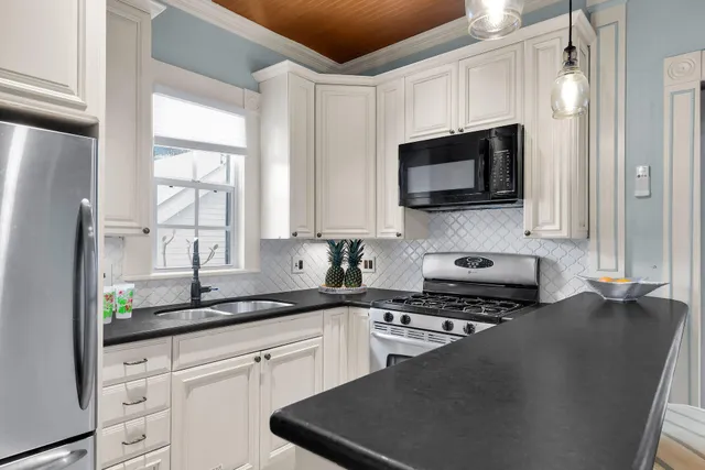 a kitchen with stainless steel appliances a stove microwave and sink