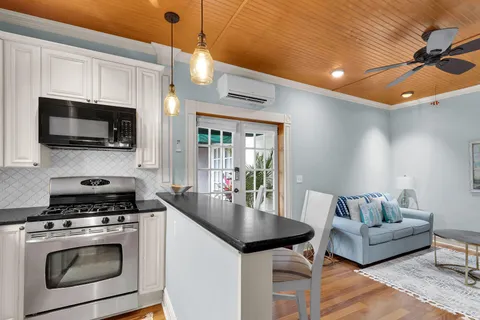 a living room with furniture a flat screen tv and kitchen view