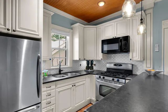 a kitchen with stainless steel appliances a refrigerator sink and microwave