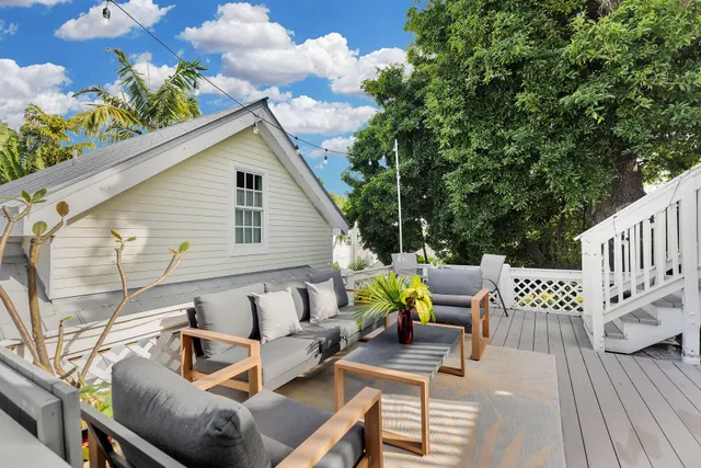 a view of a patio with couches table and chairs and potted plants