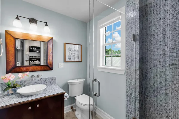 a bathroom with a toilet a sink and mirror
