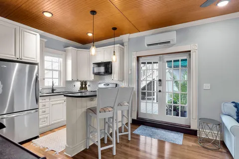 a kitchen with stainless steel appliances granite countertop a refrigerator oven a sink dishwasher and white cabinets with wooden floor