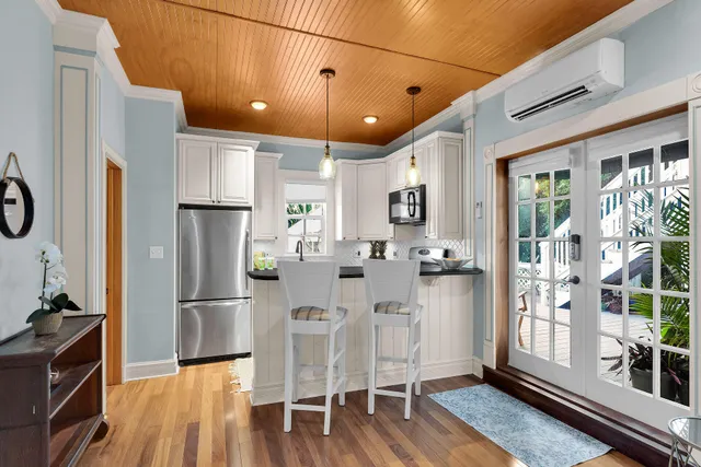 a kitchen with stainless steel appliances refrigerator dining table and chairs