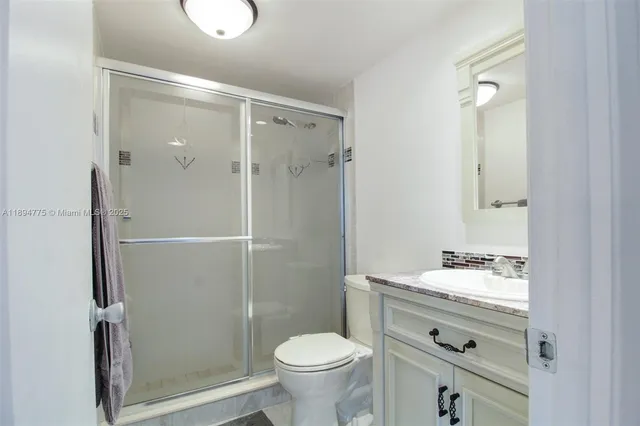 a bathroom with a granite countertop sink toilet and shower