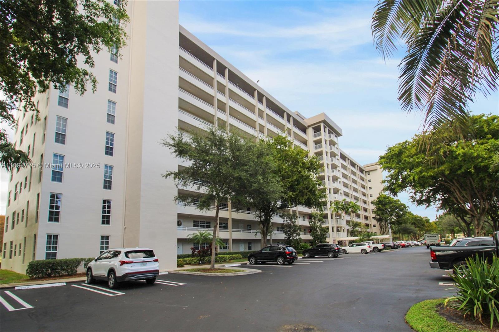 605 Oaks Drive, Unit 305 Pompano Beach, FL 33069 - Photo 24 of 31 a car parked in front of a building and trees