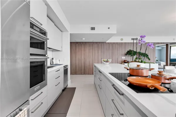 a kitchen with stainless steel appliances kitchen island granite countertop a stove a sink and a refrigerator