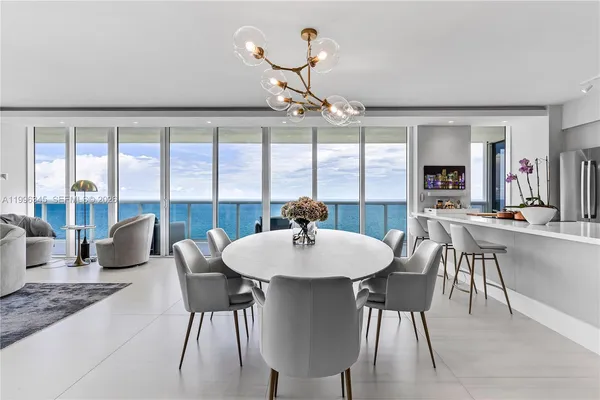 a dining room with furniture a chandelier and window