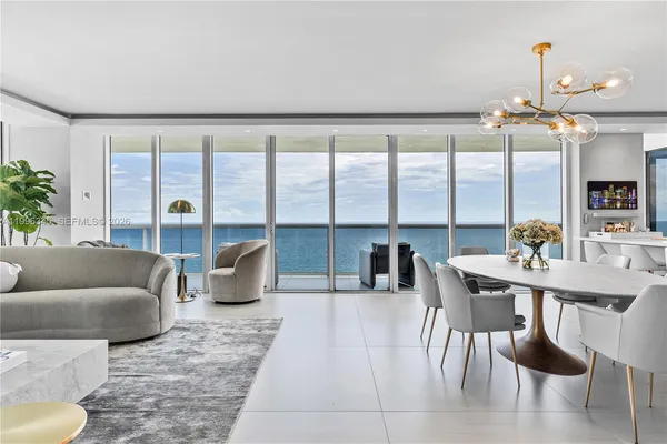 a living room with furniture and a floor to ceiling window