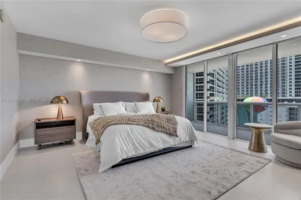 a bedroom with a bed a table and potted plant