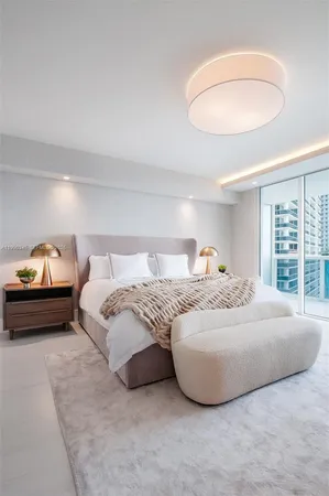 a bedroom with a bed and a large window