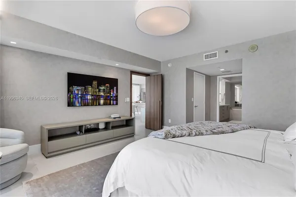 a bedroom with a bed and a flat screen tv
