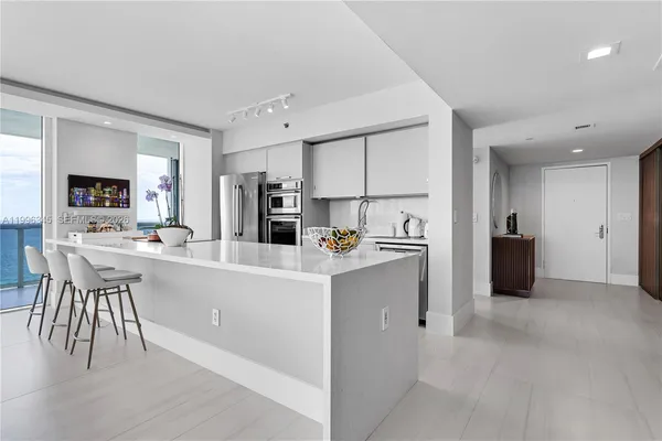 a kitchen with kitchen island a sink and a refrigerator