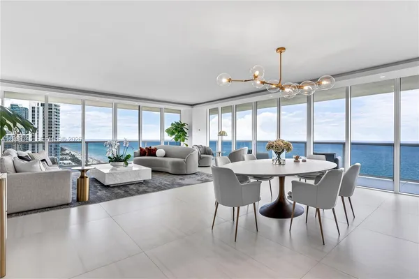 a view of a dining room with furniture large windows and wooden floor