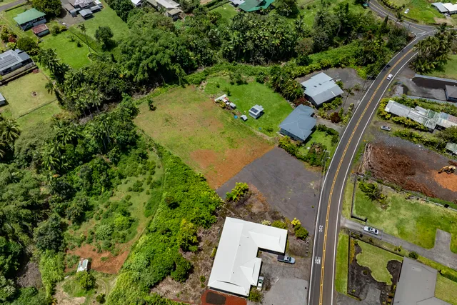 an aerial view of a residential houses with yard