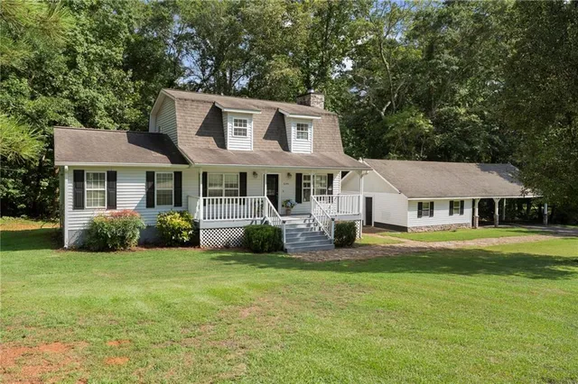 a view of a house with a big yard and large trees