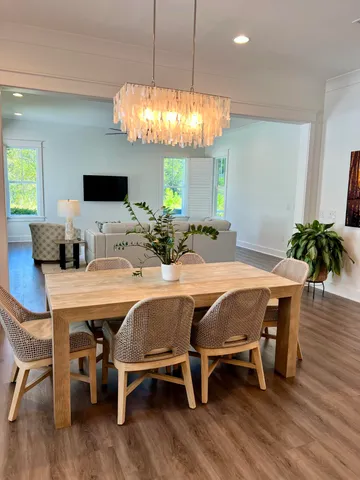 a dining room with furniture potted plants and wooden floor