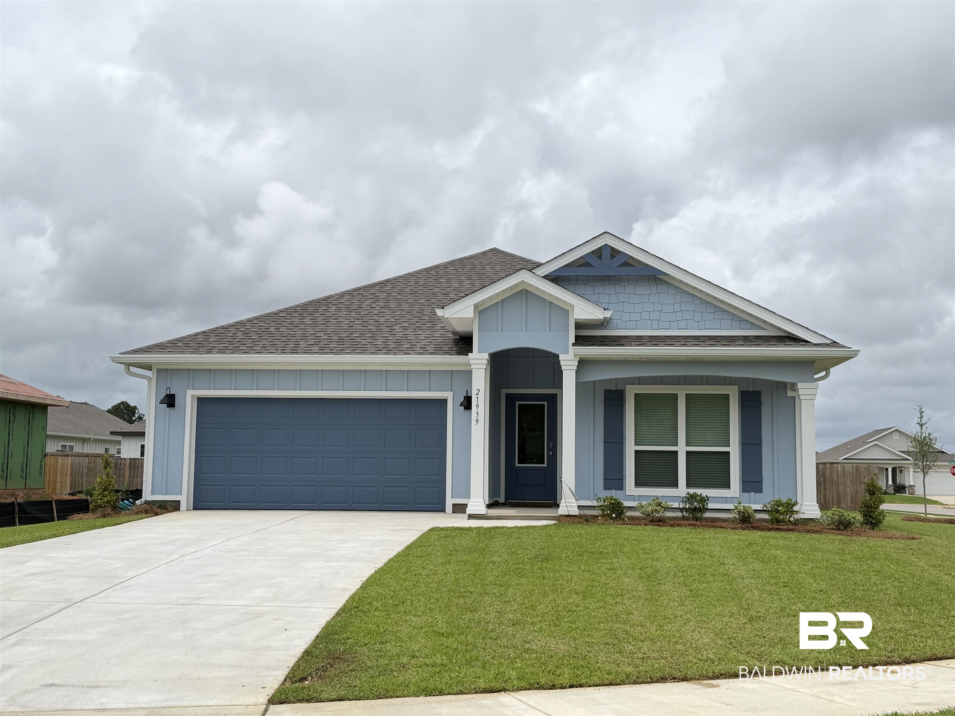 21939 Old Hbr Way Foley, AL 36535 - Photo 1 of 40 Light blue siding exterior featuring a dark blue garage door and matching front door
