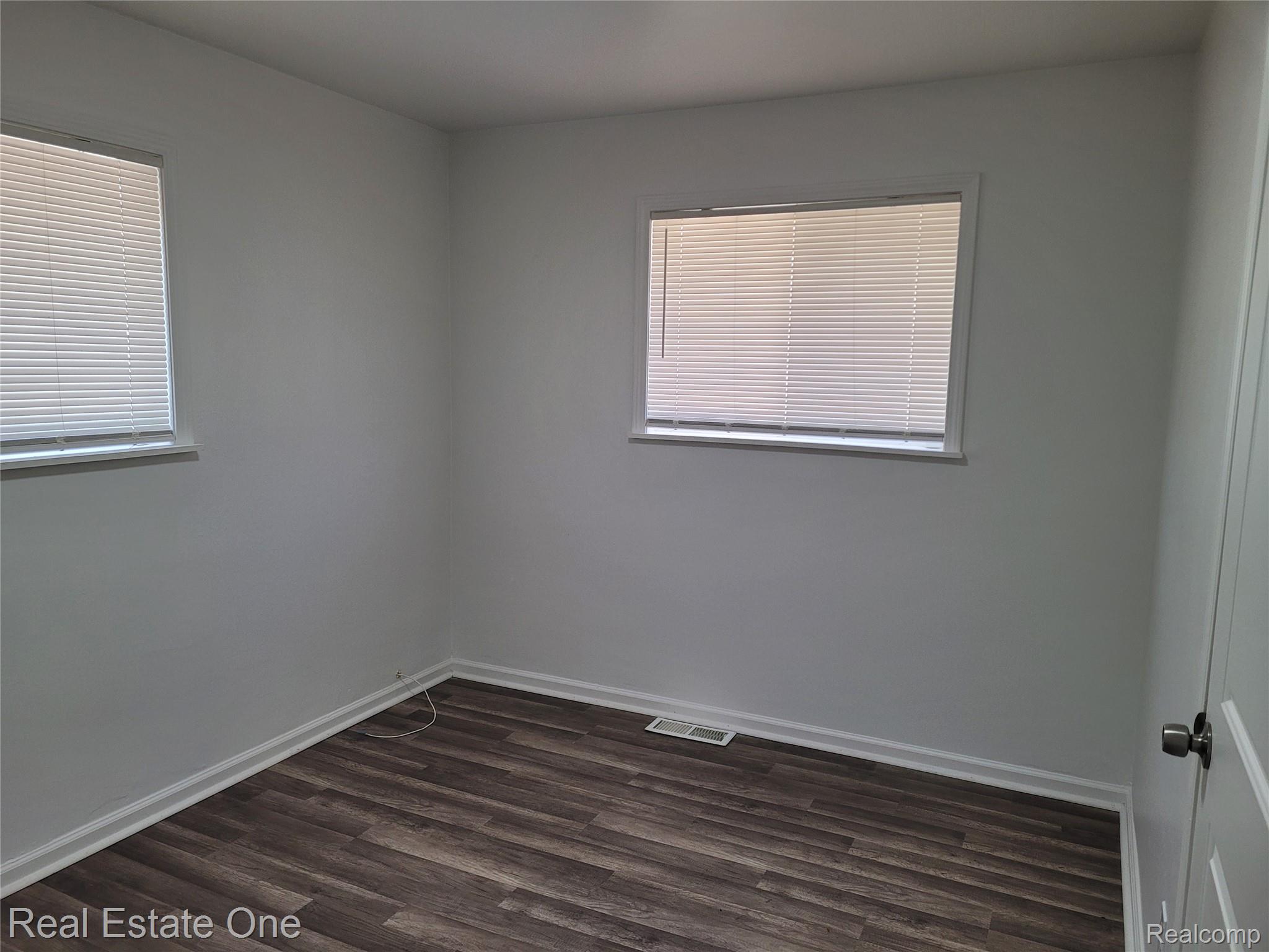 77 West Rutgers Avenue Pontiac, MI 48340 - Photo 8 of 12 Empty room featuring dark wood-type flooring and baseboards