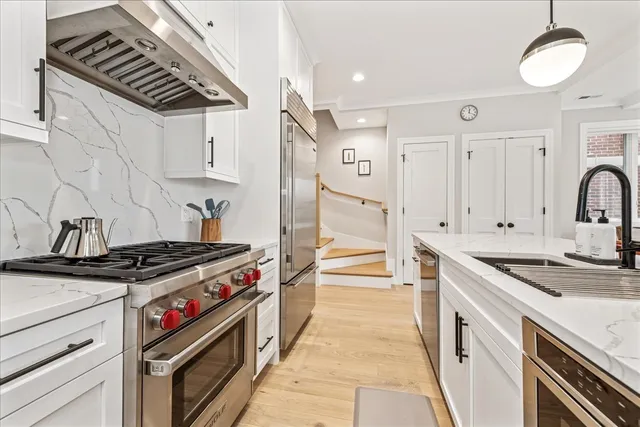 a kitchen with stainless steel appliances a stove a sink and cabinets