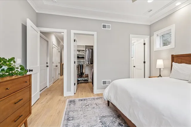 a spacious bedroom with a bed and a dresser