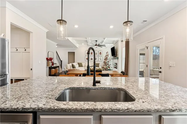 a view with granite countertop a sink a counter top space and living room view