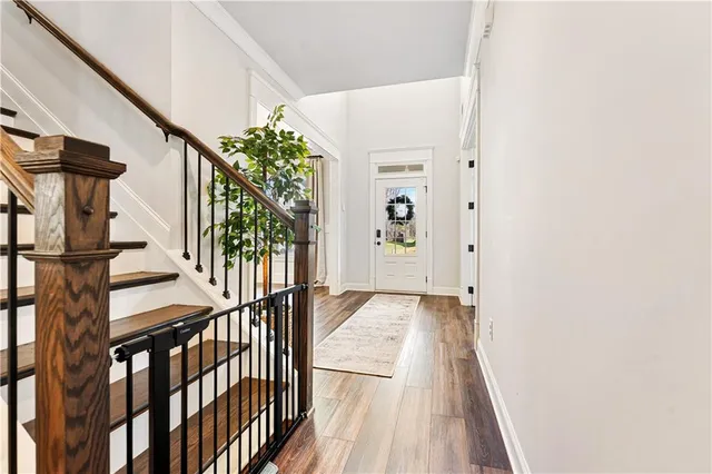 a view of staircase with lots of frames on wall and wooden floor
