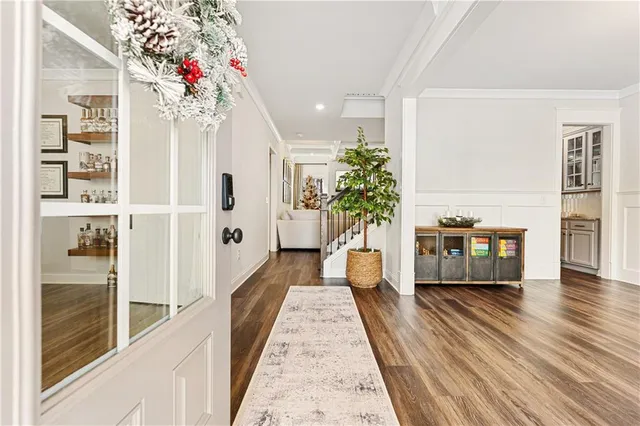 a hallway with wooden floor and flower vase