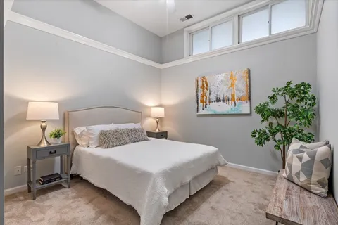 a bedroom with a bed and a potted plant