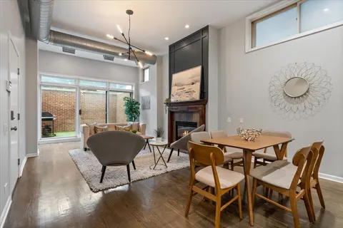 a dining room with furniture a chandelier and wooden floor