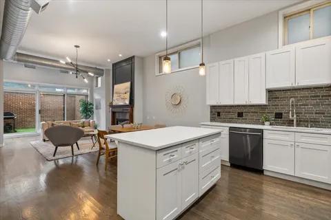 a kitchen that has a lot of cabinets in it and wooden floors