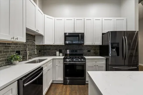 a kitchen with a sink and steel appliances